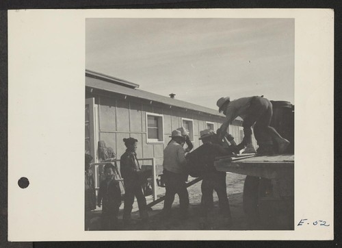 A crew delivering U.S. Army No. 1 Space Heaters to a resident barracks at the Topaz Center. Photographer: Parker, Tom Topaz, Utah