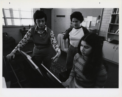 Scripps College student Julie Simon plays piano while Professor Jane O'Donnell coaches her, Scripps College