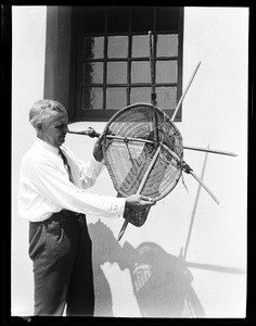 Man holding what appears to be a Native American shield at the Pacific Southwest Museum