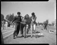 Track athletes support an injured teammate, Los Angeles, 1937