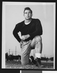 University of Southern California assistant football coach Bill Fisk, dark sweatshirt, on one knee, Bovard Field, 1949