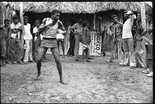 Man boxing outdoor in front of a crowd, San Basilio de Palenque, 1975