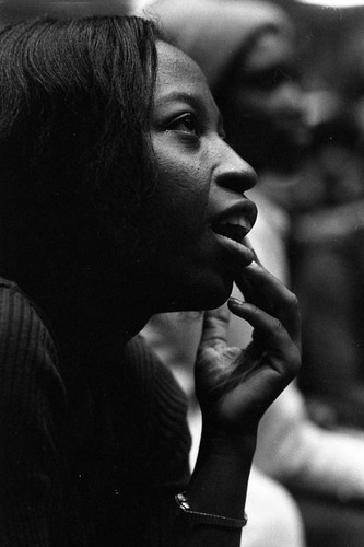 Woman listening to Dick Gregory speak, 1973