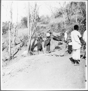 Two men carrying a sick person, Tanzania, ca.1927-1938