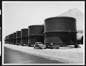 Construction at Boulder Dam, showing a row of cylindrical tanks, ca.1930