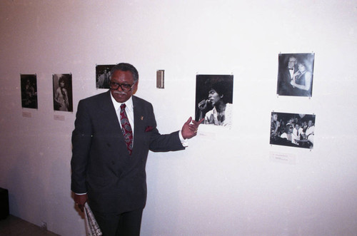 Guy Crowder point to one of the photographs in his exhibit, Los Angeles, 1993