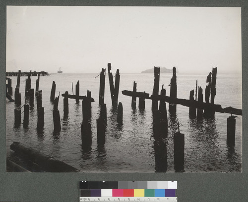[Burnt piers of wharf. Alcatraz Island, right center. From North Beach?]
