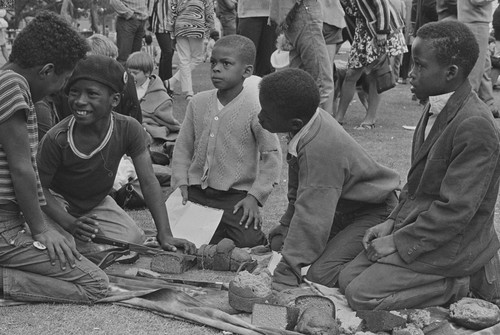 Children cutting bread which was brought to the Free Huey Rally by the Diggers, De Fremery Park, Oakland, CA, #35 from A Photographic Essay on The Black Panthers