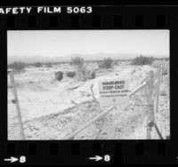 Barbwire fence with sign reading "Warning Keep Out Illegal Chemical Dump" in Antelope Valley, Calif., 1981