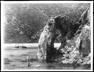 Arch Rock on Santa Catalina Island, with yachting party in the schooner Fleetwing in the water in the background, ca.1905