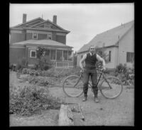 Guy West stands with his bicycle in the West's backyard, Los Angeles, about 1903
