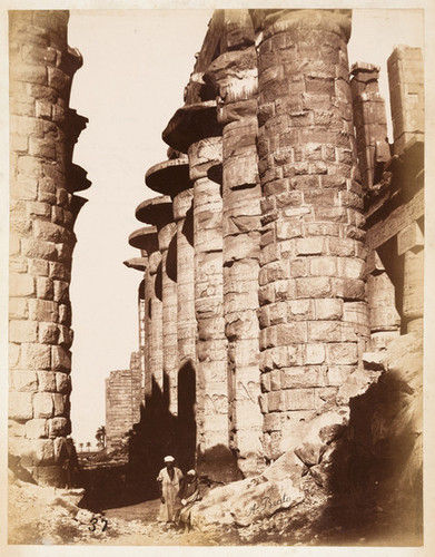 37. [View of the magnificent colonnade in the great hypostyle hall of the Temple of Amon-ra in Karnak, in Upper Egypt; two Nubian figures at the base of a column]
