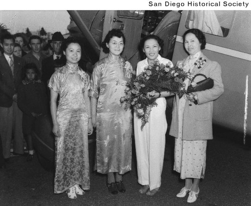 Four Chinese women standing at the door of an airplane