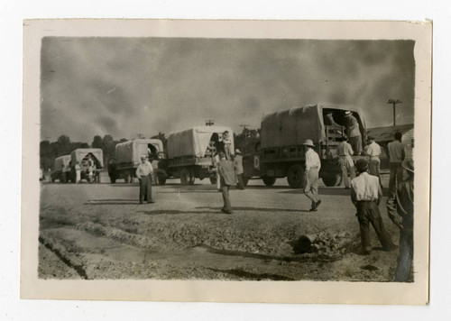 Convoy of covered trucks leaving Jerome camp for Tule Lake camp