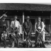 Four men with dead ducks
