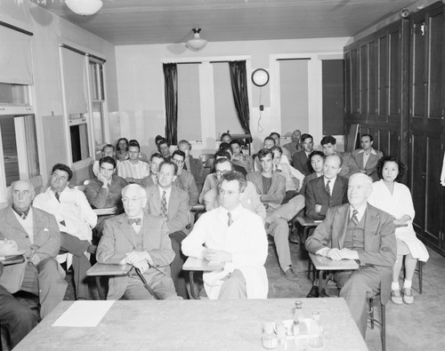 Seminar at Scripps Institution of Oceanography held in the George H. Scripps Memorial Marine Biological Building classroom. Row 1 (Left, front to back): O. Bendisch; Carl L. Hubbs; G. Groves?; Carl Oppenheimer; Bill Quinn; unidentified; and Jean Sullivan. Row 2: Miller; Russell Raitt; Robert S. Arthur; N.A. Buchwald; John Isaacs; unidentified; and Lela Jeffrey?. Row 3: Claude E. ZoBell; Fred Phleger; Tom Bowma;, Gene Corcoran?; Edward Goldberg; Richard Morita; and unidentified man. Row 4: (Short student row): Dave Arthur; Bob Maher; Fred Sisler; and unidentified man. Row 5: Dr. Wesley R. Coe; Phil Rudnick; Lin; Arthur Kelly; Picard; and Stanley Chambers. Extreme right: Mrs. Lin; and John Cochrane. March 1, 1950