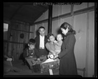 Returning Japanese American internees Masashi Sakatani and his children unpacking in Army barracks in Burbank, Calif., 1945