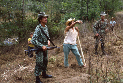 Soldier question Mayan man about guerilla movements, Guatemala, 1982