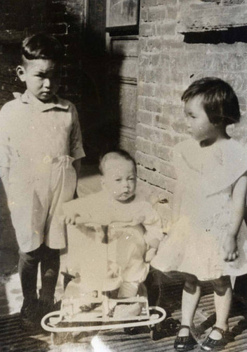 Three children, one boy, one girl and a baby in the center