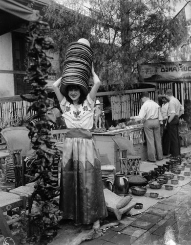 Girl with many hats on Olvera Street