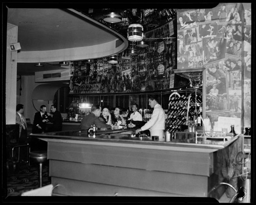 Interior of an unidentified bar, with bartender and customers