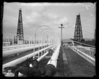 Pipeworks and oil well towers in the Los Angeles County, Calif. Coyote oil fields, circa 1920