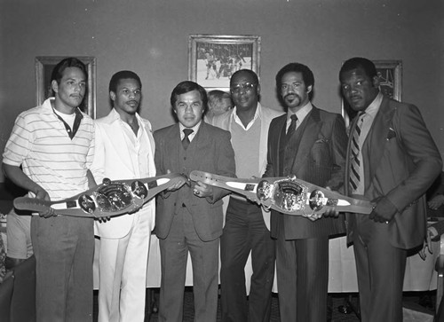 Brad Pye and others posing with championship boxing belts, Los Angeles, 1978