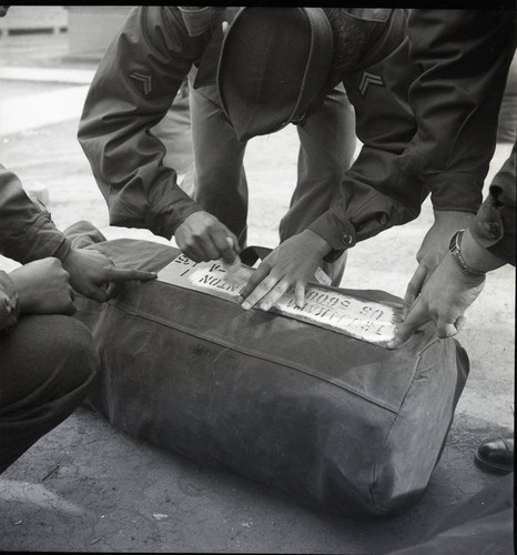 Soldiers labeling their duffle bags