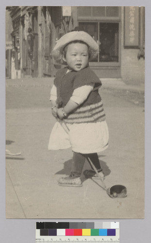 [Chinese child playing on sidewalk]