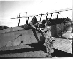 Pilot Sam Huck Sr. in his Curtiss JN-4 "Jenny" biplane, receiving flowers from "Tee" McMinamin (Rose), writer for the San Francisco Examiner, at the May 16, 1928 Air Show