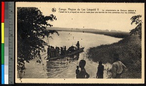Missionary father pushing off into a lake aboard a narrow boat, Congo, ca.1920-1940