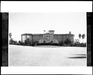 Exterior view of the Ambassador Hotel with a large sign for the Cocoanut Grove and Ozzie Nelson, 1936