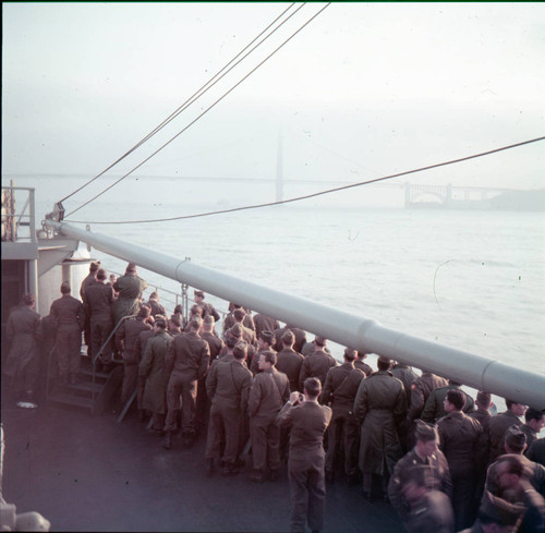 Servicemen crowd the deck to see the Golden Gate Bridge