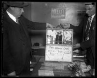 Two Los Angeles policemen displaying the briefcase bomb Timothy P. Blevins used in 1932 attempted bank robbery