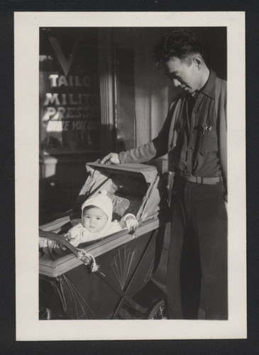 Man and baby in front of laundry shop