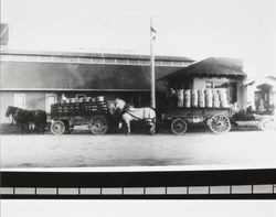 Horse drawn wagons loaded with butter parked in front of Petaluma Cooperative Creamery, about 1918