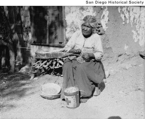 Elderly Indian woman weaving a basket