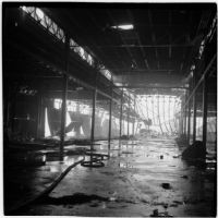View from below of the damage done to a marine terminal after the Markay oil tanker exploded in L.A. Harbor, Los Angeles, 1947
