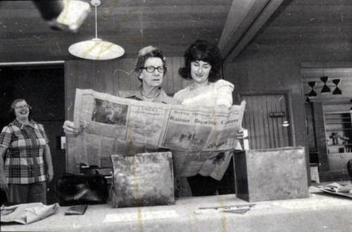 Mary Root and and Mrs. John Goldsborough looking at a newspaper