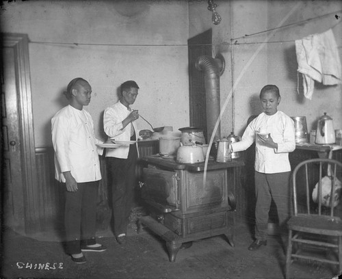 Three Chinese men cooking in kitchen. [negative]