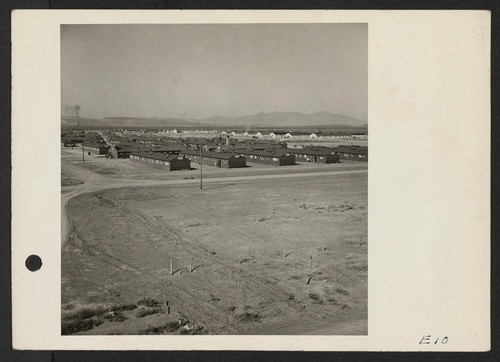 General view of a section of the Topaz center. White buildings in the background and the hospital, right; administrative buildings, left. Photographer: Parker, Tom Topaz, Utah
