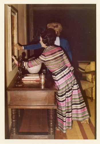 Mrs. Alice Tyler and a guest admiring a painting in the Brock House--Pose 1 (Color)