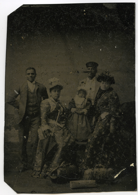 Portrait of two unidentified couples with child and suitcases
