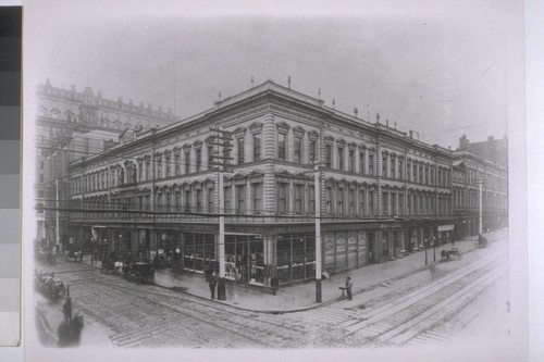 Lick House, southwest corner Montgomery & Sutter, 1899. Masonic Temple cupola; Crocker Building. Telephone wires, a wire for each telephone prior to cable system; light poles. Hastings Clothing Store, first started in Lick House, foreground. Street vendor, probably selling eyeglasses--the purchaser was given a card and kept trying on glasses until he found a pair through which he could read the card, paid the seller 50 cents, and hooked the new glasses onto his nose