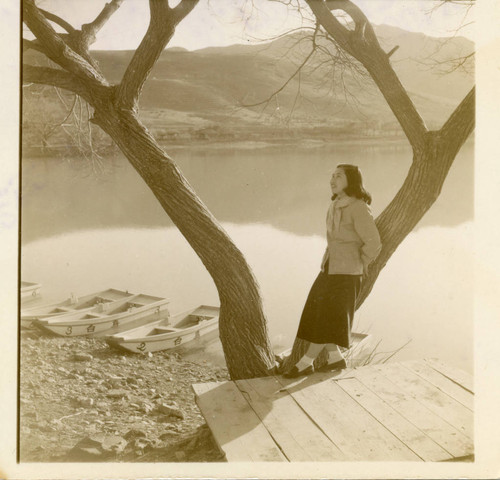 Portrait of an unidentified woman leaning on tree by a river in Korea