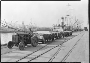 Cotton bales being pulled along a wharf in Los Angeles Harbor, March 5, 1931