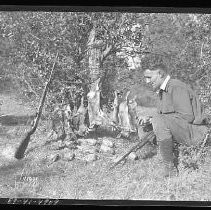 Hunter with dead partridge and rabbits