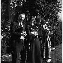 Man and two woman standing on a lawn