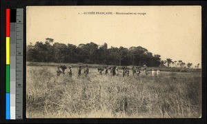 Missionaries walking with a long line of porters, Guinea, ca.1920-1940