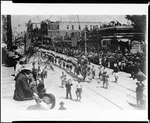 Spectators observing the Chinese dragon in a parade at the Los Angeles Fiesta, 1901